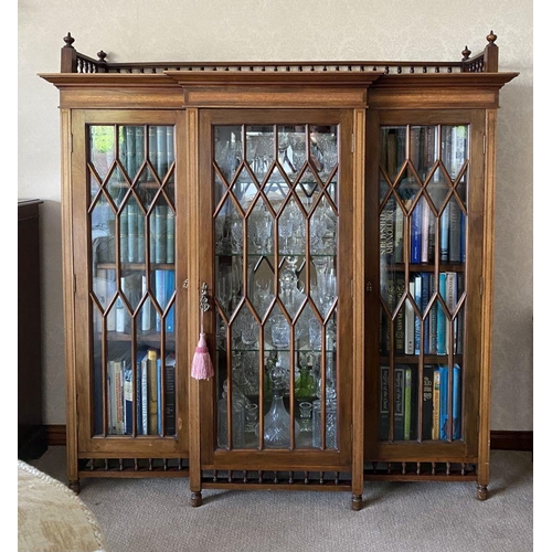 49 - A FINE ASTRAL GLAZED BREAKFRONT THREE DOOR DISPLAY CABINET, with three quarter gallery to top above ... 