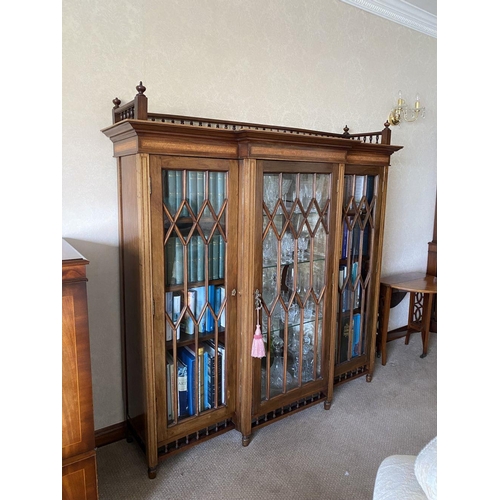 49 - A FINE ASTRAL GLAZED BREAKFRONT THREE DOOR DISPLAY CABINET, with three quarter gallery to top above ... 