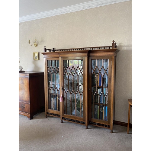 49 - A FINE ASTRAL GLAZED BREAKFRONT THREE DOOR DISPLAY CABINET, with three quarter gallery to top above ... 