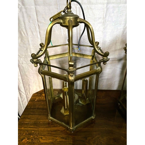 93 - A VERY GOOD QUALITY PAIR OF BRASS GLAZED HANGING LANTERN LIGHTS, each with scrolling open work to th... 