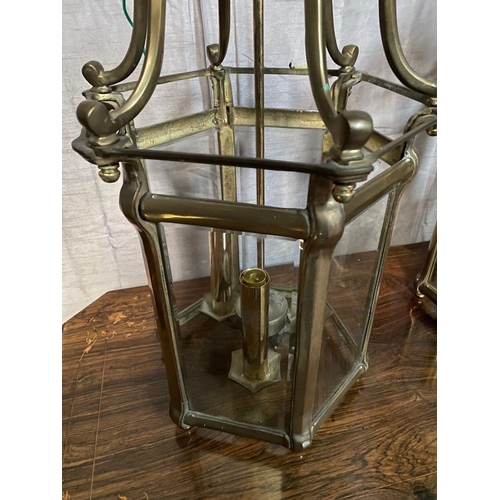 93 - A VERY GOOD QUALITY PAIR OF BRASS GLAZED HANGING LANTERN LIGHTS, each with scrolling open work to th... 