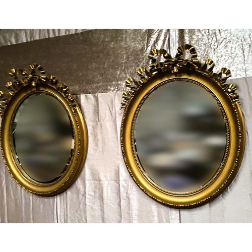 99 - A VERY GOOD QUALITY PAIR OF OVAL SHAPED GILT WALL MIRRORS – DECORATED WITH BEAUTIFUL SCROLLING RIBBO... 