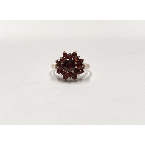 114 - A VINTAGE 9CT GOLD GARNET CLUSTER RING, with central round cut garnet in eight claw setting surround... 