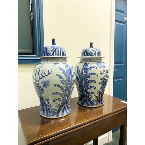 13 - A PAIR OF CHINESE PORCELAIN BLUE AND WHITE TEMPLE VASES, c. late Qing period, with domed cover with ... 