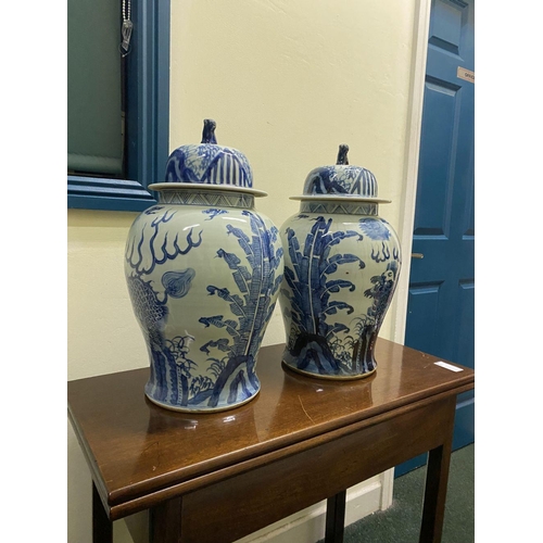 13 - A PAIR OF CHINESE PORCELAIN BLUE AND WHITE TEMPLE VASES, c. late Qing period, with domed cover with ... 