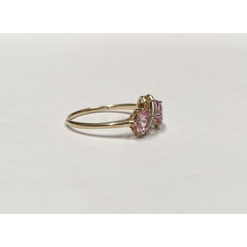 16 - A BEAUTIFUL 9CT GOLD PINK THREE STONE RING, with three pink round cut gemstones in four prong raised... 