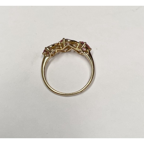 16 - A BEAUTIFUL 9CT GOLD PINK THREE STONE RING, with three pink round cut gemstones in four prong raised... 