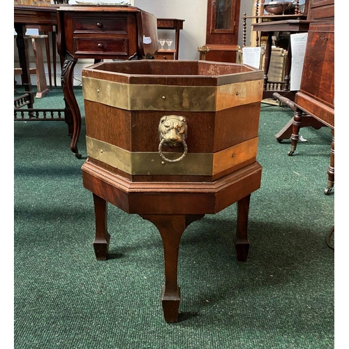 17 - A GOOD QUALITY REGENCY BRASS BOUND MAHOGANY WINE COOLER, octagonal in shape, with liner, lion head b... 