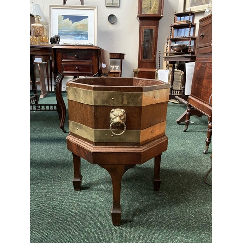 17 - A GOOD QUALITY REGENCY BRASS BOUND MAHOGANY WINE COOLER, octagonal in shape, with liner, lion head b... 