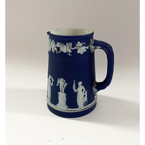 181 - AN ANTIQUE BLUE JASPERWARE SMALL PITCHER, by Wedgewood. Decorated with applied white classical scene... 