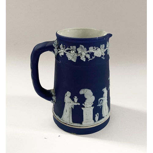 181 - AN ANTIQUE BLUE JASPERWARE SMALL PITCHER, by Wedgewood. Decorated with applied white classical scene... 