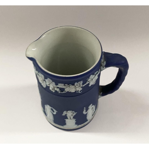 181 - AN ANTIQUE BLUE JASPERWARE SMALL PITCHER, by Wedgewood. Decorated with applied white classical scene... 