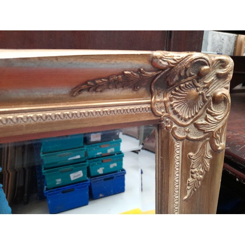 202 - A VERY GOOD QUALITY GILT WALL MIRROR, with scrolling foliage detail to the corners & edges, nice bev... 