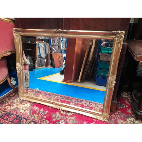 202 - A VERY GOOD QUALITY GILT WALL MIRROR, with scrolling foliage detail to the corners & edges, nice bev... 