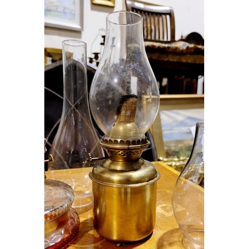 215 - A COLLECTION OF ANTIQUE GLASS & BRASS OIL LAMPS, along with spare clear glass chimneys.