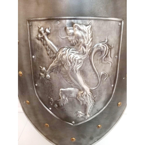 47 - A LARGE DECORATIVE METAL SHIELD, with lion decoration. Dimensions: 63cm high 45cm wide.