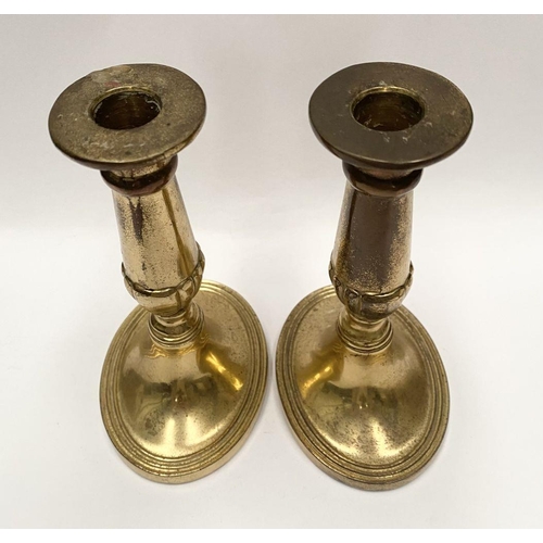 78 - A FINE PAIR OF BRASS CANDLESTICKS, with fluted design to support, atop platform oval bases. Marked M... 