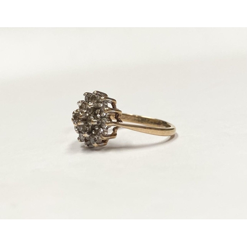 88 - AN ORNATE 9CT GOLD CLUSTER RING, with central round cut clear gemstone surrounded by two rows of gem... 