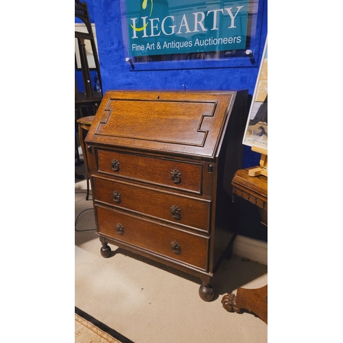 105 - AN EARLY 20TH CENTURY OAK FALL FRONT SECRETAIRE, the graduated fall front door with raised moulding ... 