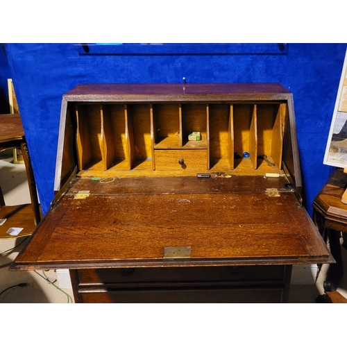 105 - AN EARLY 20TH CENTURY OAK FALL FRONT SECRETAIRE, the graduated fall front door with raised moulding ... 