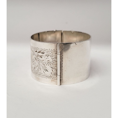 143 - A VERY GOOD QUALITY IRISH SILVER BANGLE, decorated with floral engraved design to one side of exteri... 