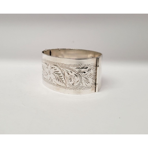 143 - A VERY GOOD QUALITY IRISH SILVER BANGLE, decorated with floral engraved design to one side of exteri... 