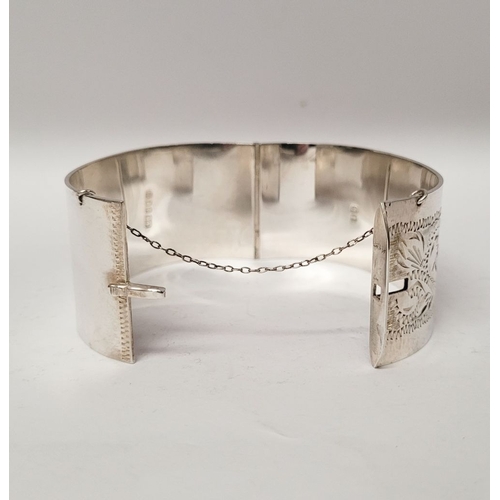 143 - A VERY GOOD QUALITY IRISH SILVER BANGLE, decorated with floral engraved design to one side of exteri... 