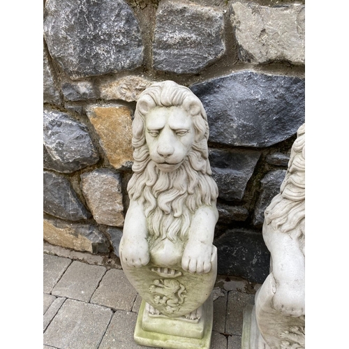 148 - A LARGE PAIR OF STONE GARDEN ORNAMENTS, in the form of lions above armorial plaque, on square steppe... 