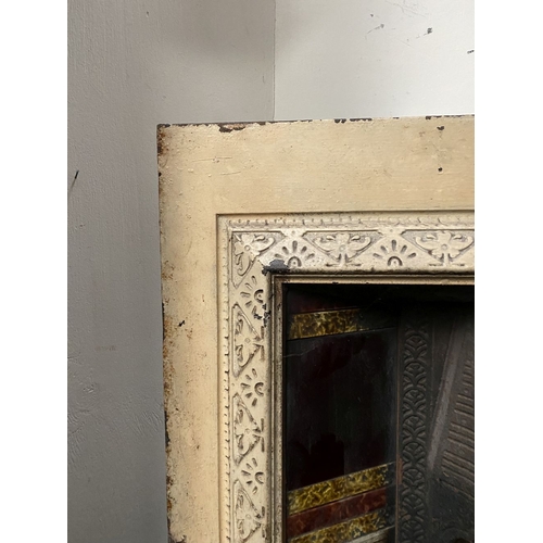 202 - A DECORATIVE ANTIQUE CAST IRON FIRE SURROUND/FIREPLACE INSERT, with original hand glazed coloured fl... 