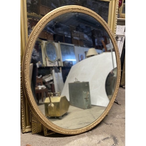 220 - A BEAUTIFUL LARGE DECORATIVE OVAL OVERMANTLE/HALL MIRROR, with intricately carved frame featuring do... 