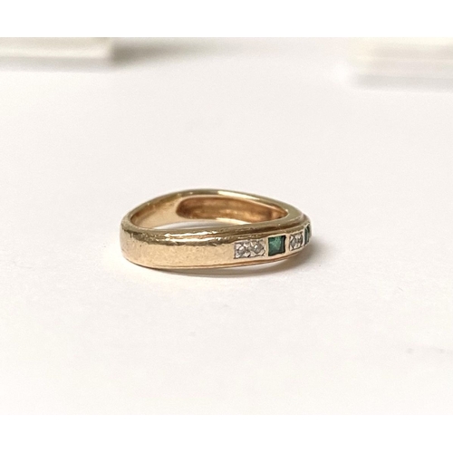 227 - A DAINTY 9CT YELLOW GOLD EMERALD AND DIAMOND BAND RING, with three princess cut emeralds, each separ... 