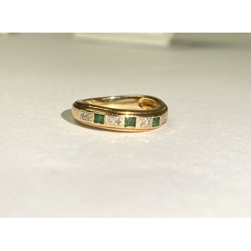 227 - A DAINTY 9CT YELLOW GOLD EMERALD AND DIAMOND BAND RING, with three princess cut emeralds, each separ... 