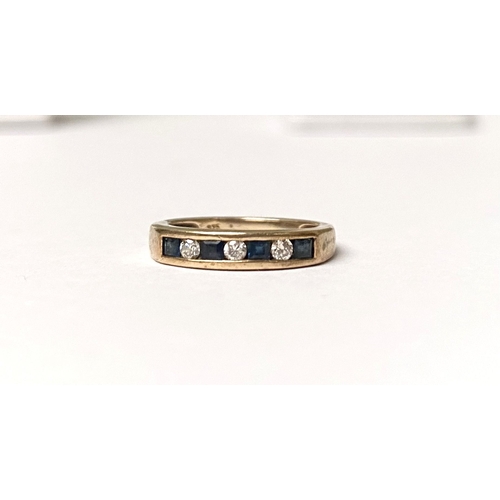 233 - A PRETTY 9CT YELLOW GOLD SAPPHIRE AND DIAMOND BAND RING, with four princess cut sapphires separated ... 