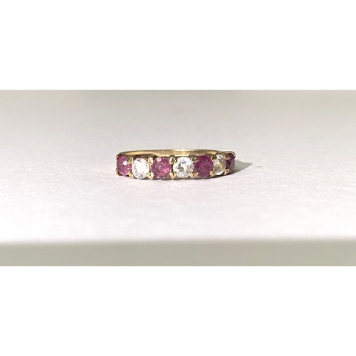 236 - A BEAUTIFUL HALF ETERNITY GEMSET BAND RING, with four round cut red gemstones separated by three rou... 