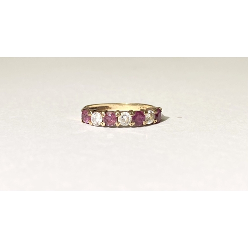 236 - A BEAUTIFUL HALF ETERNITY GEMSET BAND RING, with four round cut red gemstones separated by three rou... 