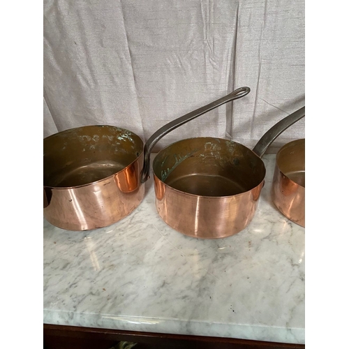 278 - A SET OF FIVE GRADUATED COPPER SAUCEPANS, with steel handles.