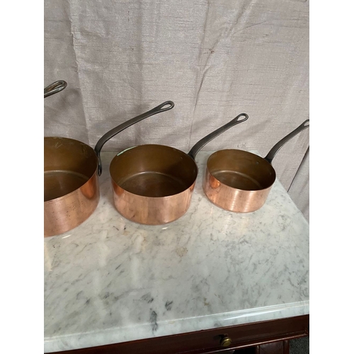 278 - A SET OF FIVE GRADUATED COPPER SAUCEPANS, with steel handles.