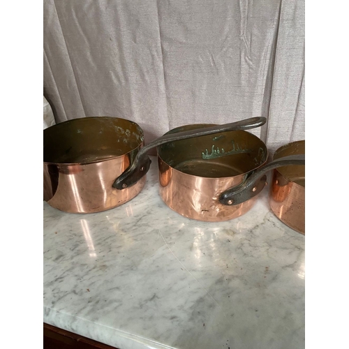 278 - A SET OF FIVE GRADUATED COPPER SAUCEPANS, with steel handles.