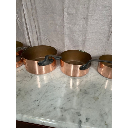 278 - A SET OF FIVE GRADUATED COPPER SAUCEPANS, with steel handles.