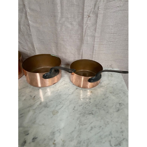 278 - A SET OF FIVE GRADUATED COPPER SAUCEPANS, with steel handles.