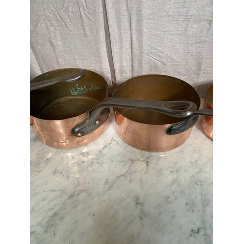 278 - A SET OF FIVE GRADUATED COPPER SAUCEPANS, with steel handles.