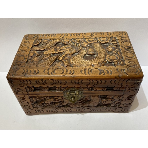 293 - A DECORATIVE CHINESE CARVED CAMHOR WOOD BOX, heavily carved throughout with decorative engraved bras... 