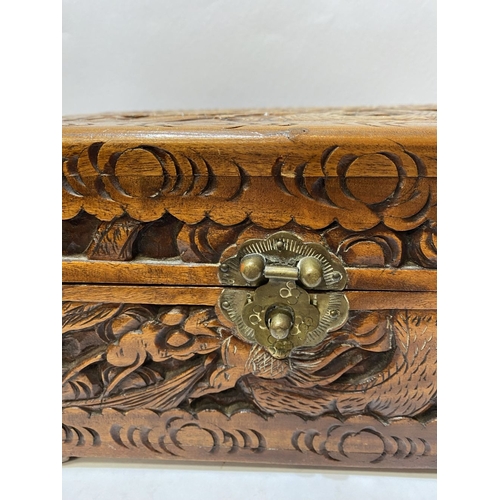 293 - A DECORATIVE CHINESE CARVED CAMHOR WOOD BOX, heavily carved throughout with decorative engraved bras... 