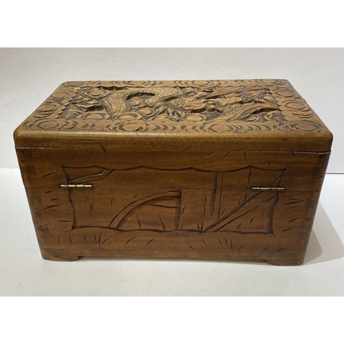 293 - A DECORATIVE CHINESE CARVED CAMHOR WOOD BOX, heavily carved throughout with decorative engraved bras... 