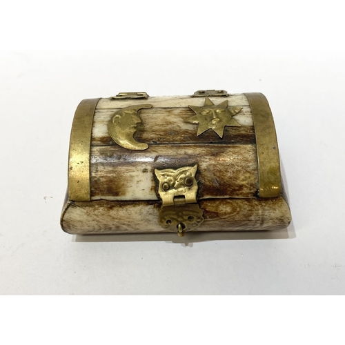 296 - AN ANTIQUE CARVED BONE TRINKET BOX, with brass bindings, decorative brass hinges and clasp to front,... 