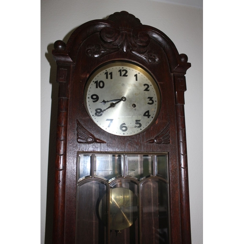 318 - A JUNGHANS CARVED WALL CLOCK, the arched carved top featuring shell motif to centre, with floral and... 