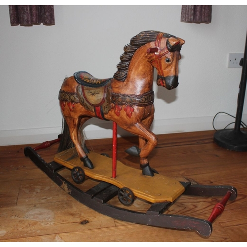 322 - AN ANTIQUE HAND PAINTED CARVED ROCKING HORSE, with glass eyes and hair to tail. Dimensions: 66cm x 9... 