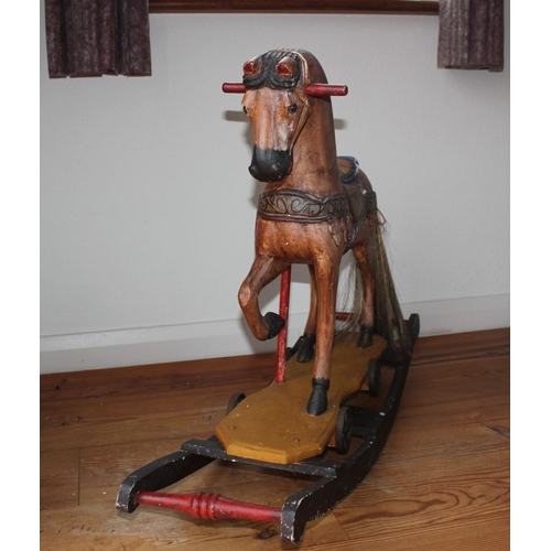 322 - AN ANTIQUE HAND PAINTED CARVED ROCKING HORSE, with glass eyes and hair to tail. Dimensions: 66cm x 9... 