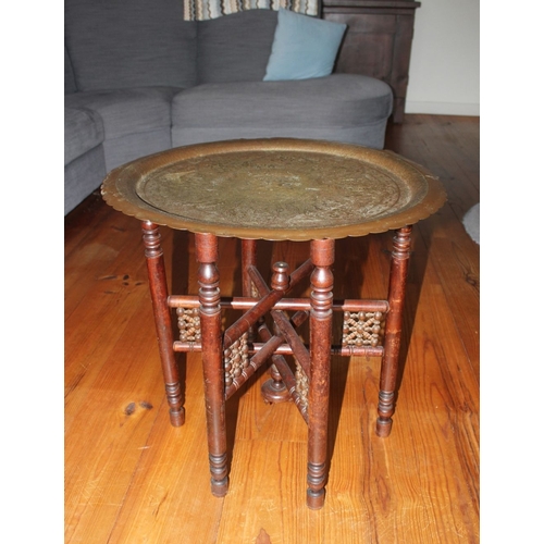 326 - AN ANGLO/INDIAN FOLDING SIDE TABLE, decorative circular brass engraved top with raised scalloped bor... 