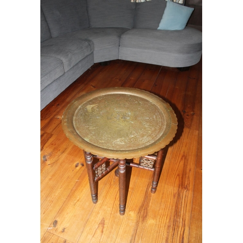 326 - AN ANGLO/INDIAN FOLDING SIDE TABLE, decorative circular brass engraved top with raised scalloped bor... 